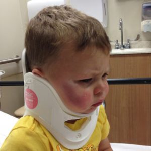 little boy in neck brace