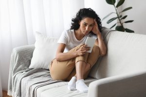 Upset woman looking at mobile phone