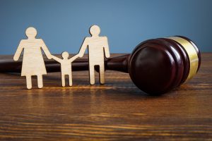 wooden cutout of a family standing next to a wooden gavel
