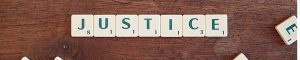 Scrabble tiles writing out "justice"